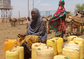 Frauen warten auf Wasserlieferung